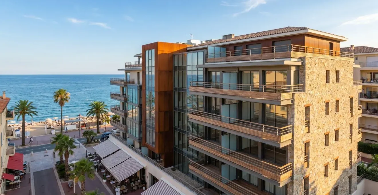 Complexe résidentiel moderne dans une ville côtière française avec appartements à balcons donnant sur la Méditerranée et infrastructures touristiques en arrière-plan